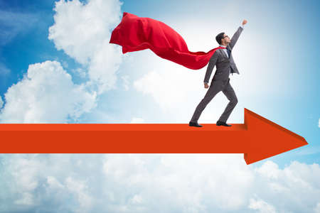 Superhero businessman standing on arrowの写真素材