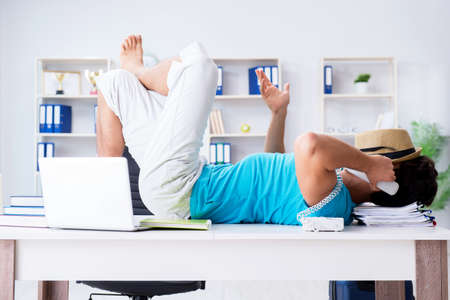 Businessman preparing for vacation in the officeの写真素材