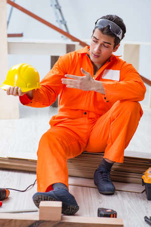 Carpenter wearing yellow hardhat in contractor workshopの写真素材