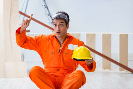 Carpenter wearing yellow hardhat in contractor workshopの写真素材