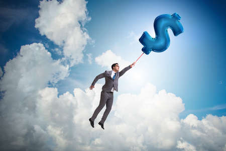 Businessman flying on dollar sign inflatable balloonの写真素材