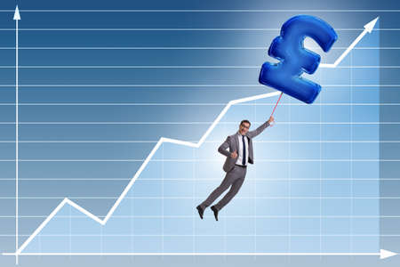 Businessman flying on british pound sign inflatable balloonの写真素材