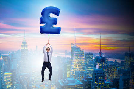 Businessman flying on british pound sign inflatable balloon