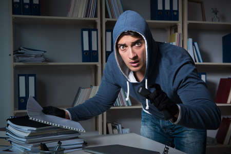 Young man in industrial espionage conceptの写真素材