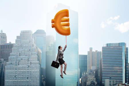 Businesswoman flying on euro sign inflatable balloonの写真素材