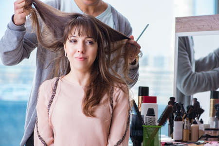 Man stylist working with woman in beauty salonの写真素材