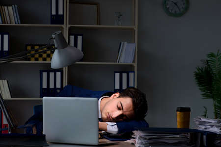 Businessman tired and sleeping in the office after overtime hourの写真素材