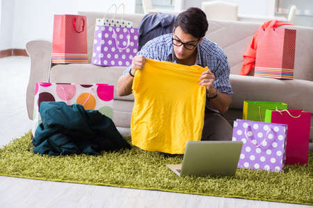 Young man buying clothing online and running blogの写真素材