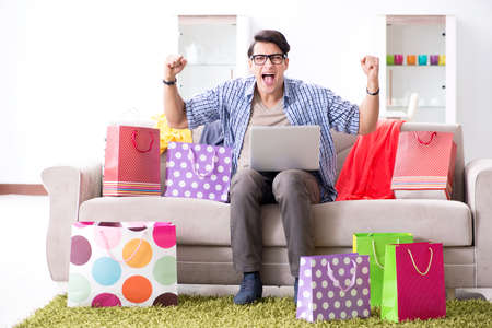 Young man buying clothing online and running blogの写真素材