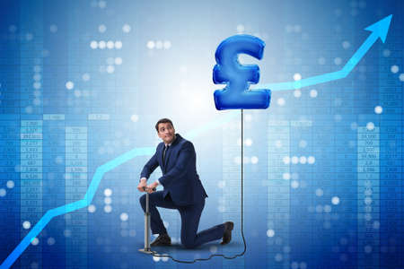 Businessman pumping british pound sterling sign in business conceptの写真素材
