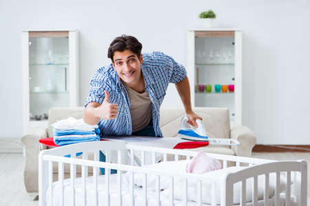 Young dad looking after newborn babyの写真素材