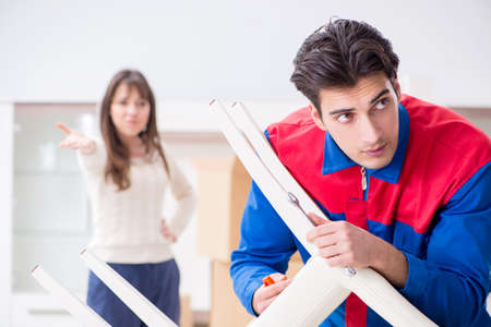 Contractor repairman assembling furniture under woman supervisionの写真素材