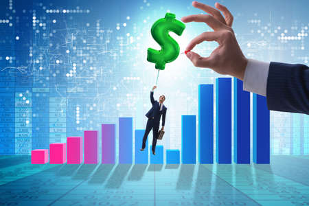 Businessman flying on dollar sign inflatable balloon over financの写真素材