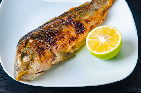 Fried fish served on the white plateの写真素材