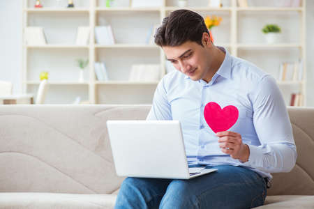 Young man making marriage proposal over internet laptopの写真素材