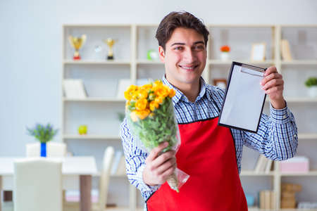Flower shop assistant offering a bunch of flowersの写真素材