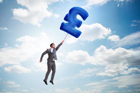 Businessman flying on british pound sign inflatable balloonの写真素材