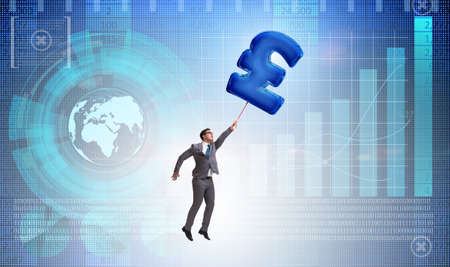 Businessman flying on british pound sign inflatable balloonの写真素材