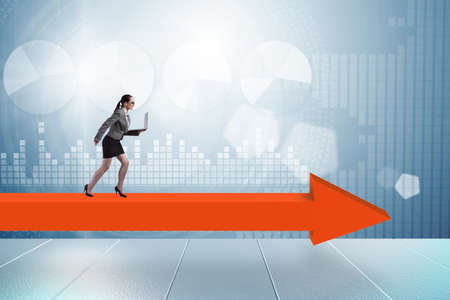 Businesswoman walking on arrow signの写真素材