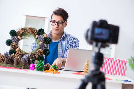 Young vlogger recording video doing christmas decoration
