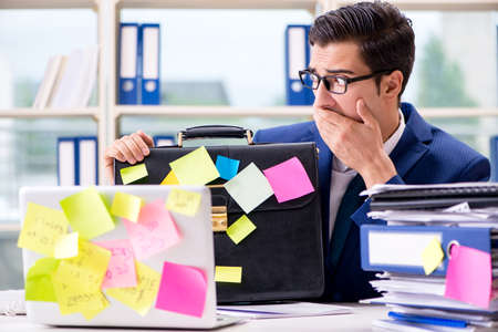 Businessman with reminder notes in multitasking conceptの写真素材