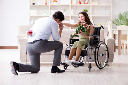 Man making marriage proposal to disabled woman on wheelchairの写真素材