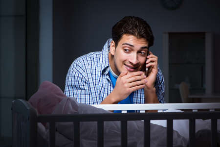 Happy dad looking after newborn baby at night