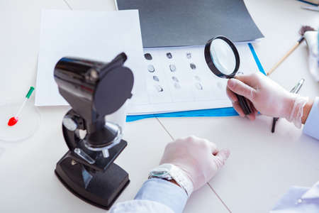Criminologist police chemist looking at crime evidenceの写真素材