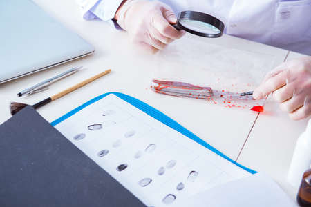 Criminologist police chemist looking at crime evidenceの写真素材