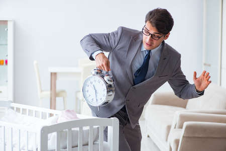 Young businessman trying to work from home caring after newborn babyの写真素材