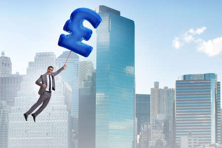 Businessman flying on british pound sign inflatable balloonの写真素材