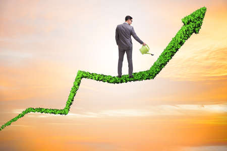 Businessman in investment concept watering financial line chartの写真素材