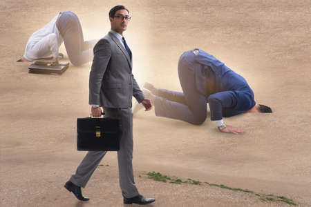 Businessman hiding his head in sand escaping from problemsの写真素材