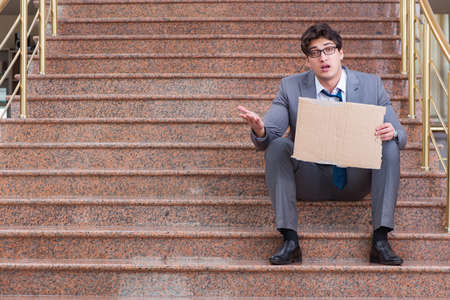 Desperate businessman begging on the streetの写真素材