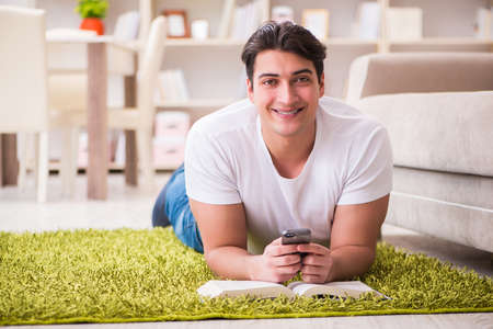 Man reading book at home on floorの写真素材