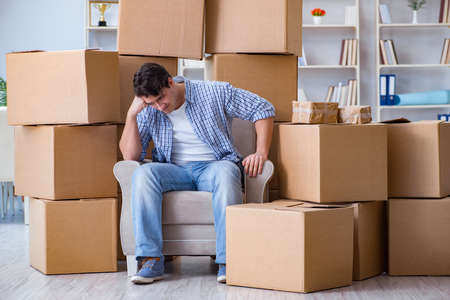 Young man moving in to new house with boxesの写真素材