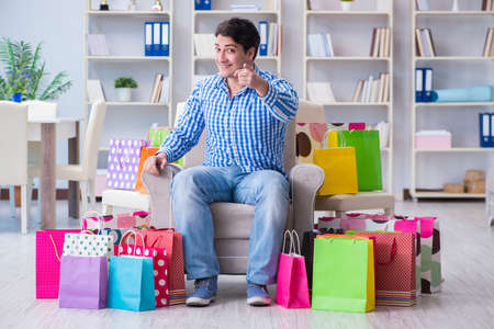 Young man after excessive shopping at homeの写真素材