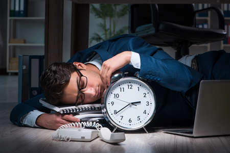 Businessman working overtime long hours late in officeの写真素材