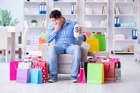 Young man after excessive shopping at homeの写真素材