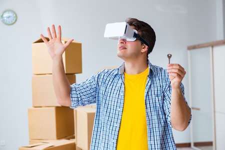 Young man wearing VR glasses moving in new apartment