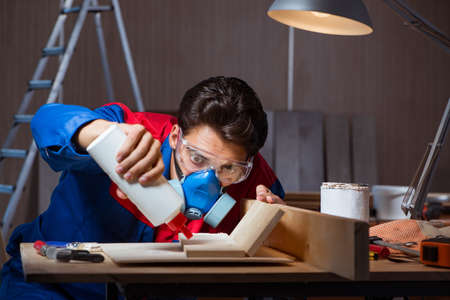 Young man gluing wood pieces together in DIY conceptの写真素材