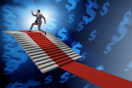 Young businessman climbing stairs and red carpetの写真素材