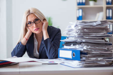 Busy businesswoman working in office at deskの写真素材