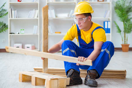 Young man assembling wood pallet