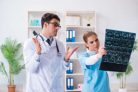 Two doctors examining x-ray images of patient for diagnosisの写真素材