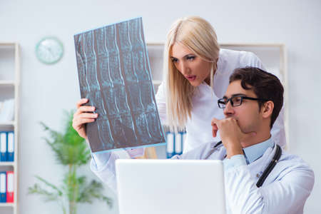 Two doctors examining x-ray images of patient for diagnosis