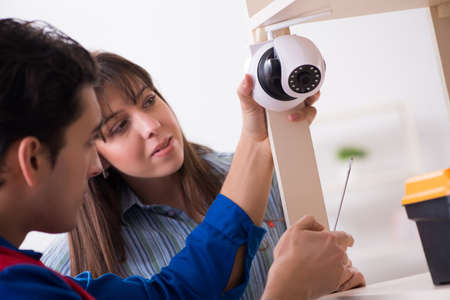Client getting securty camera installed at home by contractor