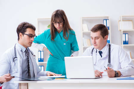 Three doctors discussing scan results of x-ray image