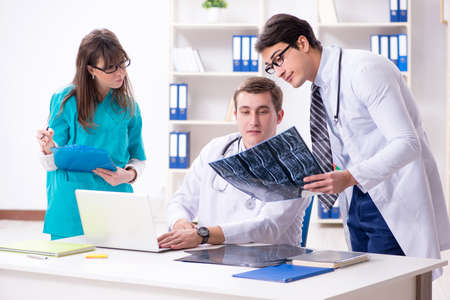 Three doctors discussing scan results of x-ray image
