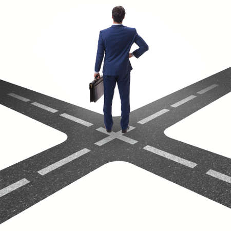 Young businessman at crossroads in uncertainty conceptの写真素材